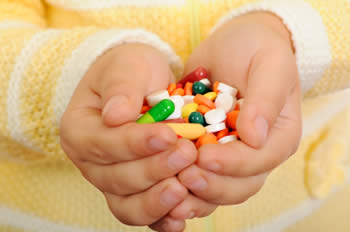 Child's hands filled with various medications