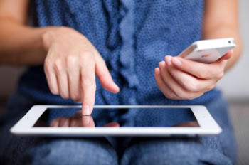 Adult woman using her ipad and iphone