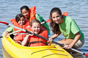 Yoith leader teaching young children to kayak