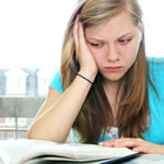 دانش آموز زن جوان که هنگام خواندن ابراز ناامیدی می کند ، نشانگر علائم دیسکسکسیا است.