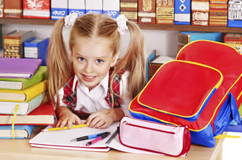 Little girl with backpack, books and school supplies
