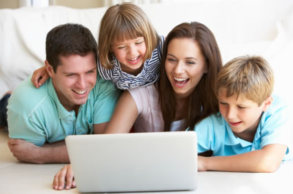 Happy family of four looking at laptop computer