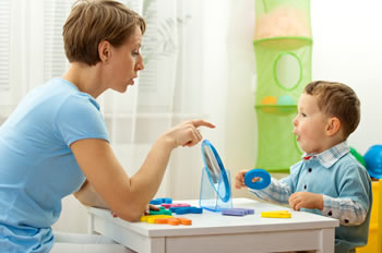 Mother working with letter toys and sounds with young son.