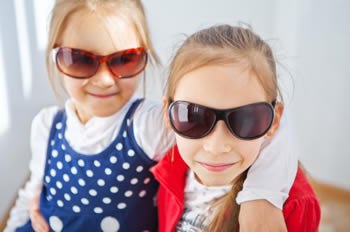 Two young girlfriends wearing oversized sunglasses